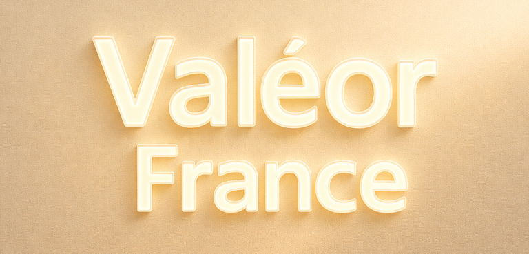 Texte en relief "Valéor" sur un fond lumineux neutre.